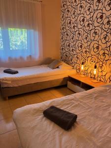 a bedroom with two beds and a wall with a window at Pokoje Gościnne u Kovi in Legnica