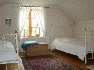 1 dormitorio con 2 camas y ventana en Trolleberg Bed & Breakfast, en Veberöd