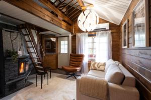 a living room with a couch and a fireplace at Lapland Aurora Riverside in Raiskio