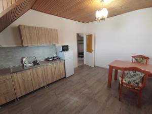 a kitchen with a table and a kitchen with a dining room at Malomrév Apartmanház Baja in Baja
