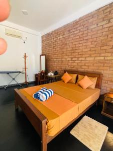 a large bed in a room with a brick wall at Sigiri Bawana in Sigiriya +42 photos