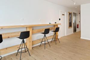 a group of stools in a room with a wooden wall at Iraipe Estella La Rúa Auto Check-in in Estella