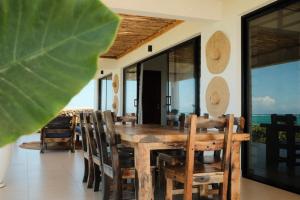 a dining room with a wooden table and chairs at Villa Kweli - Private Ocean Front Villa in Tongoni +31 photos