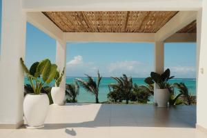 a room with a view of the ocean and palm trees at Villa Kweli - Private Ocean Front Villa in Tongoni