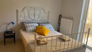 una camera da letto con letto e cuscini gialli di Amaryllis Apartments a Braurone