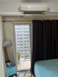 a bedroom with a window with a view of a building at MOA Staycation Condotel PASAY in Manila +4 photos