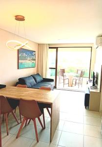 un soggiorno con un tavolo e un divano di Flat Beira Mar - Carneiros Beach Resort a Tamandaré