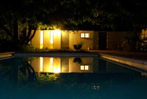 a swimming pool at night with lights in a yard at Trolleberg Bed & Breakfast in Veberöd