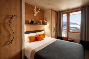 a hotel room with a bed and a window at Hôtel L'Arboisie in Megève