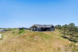 a house on top of a grassy hill at FAN021-Fano-Strandgardsvej-20-C in Fanø