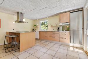 Una cocina con gabinetes de madera y un refrigerador de acero inoxidable. en FAN040-Fano-Nymarken-1, en Fanø