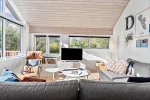 a living room with a couch and a tv at FAN007-Fano-Blommens-Toft-5 in Fanø