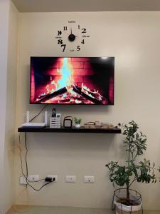 a clock on a wall with a tv on a wall at Avida Towers in Davao City