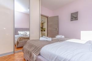 een slaapkamer met twee bedden en een grote spiegel bij Suprema Vista in Split