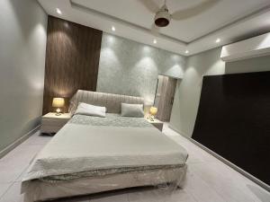 a bedroom with a large bed and a flat screen tv at 2BR Modern Home in the heart of lahore New gardentown in Lahore
