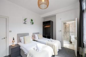 a bedroom with two beds with white sheets at Central Sleeps 6 Stunning 2 Bed by City SuperHost in Manchester