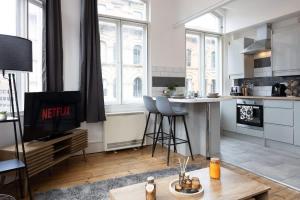 a living room with a kitchen with a tv and a table at Central Sleeps 6 Stunning 2 Bed by City SuperHost in Manchester