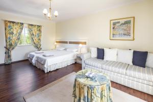 ein Wohnzimmer mit einem Bett und einer Couch in der Unterkunft Villa Botanica in Canhestros + 21 Fotos