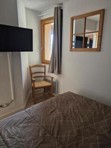 une chambre avec un lit, une chaise et une fenêtre dans l'établissement Appart bien situé, belle presta, à Orcières