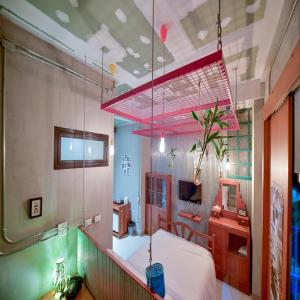 バンコクにあるCollection O Jasaen Stylish Boutique Hotelのベッドと机とテレビのある寝室