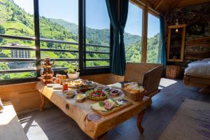 a table with food on it in a room with mountains at Cuneli bungalov in Çamlıhemşin +48 photos
