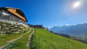 a grassy hill with a building on top of it at Panorama Dolomiti in San Vigilio Di Marebbe