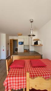 a kitchen with a table with a red checkered table cloth at Panorama Dolomiti in San Vigilio Di Marebbe