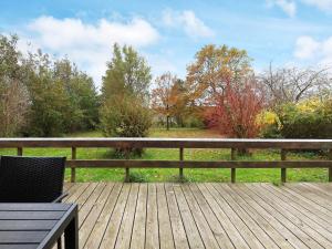 a wooden deck with a table and chairs on it at Seaside Rustic Retreat - By Traum Ferienwohnungen in Flovtrup
