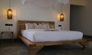 a large white bed in a bedroom with two lights at Our Stay Mlima in Arusha +55 photos