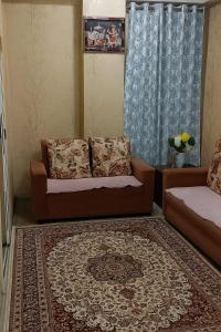 a living room with a couch and a rug at KD Homestay in Guwahati
