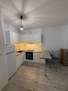 a kitchen with white cabinets and a table and a ceiling at RESORTLuxurySPA in Wrocław