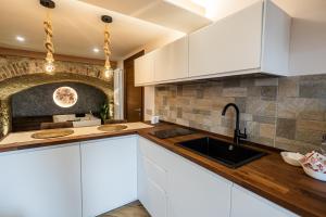a kitchen with white cabinets and a sink at Luna Gemella Suite & SPA in Calitri
