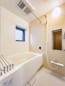 東京にあるSkytree STAR 11 Hotelの浴槽と窓のある白いバスルーム
