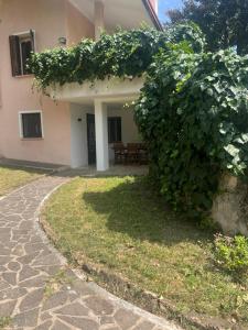 a building with a large green bush in front of it at Villa Rosa in Borso del Grappa