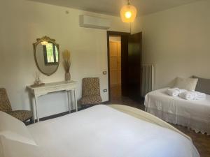 a room with two beds and a mirror and a table at Villa Rosa in Borso del Grappa