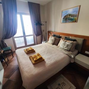 Un dormitorio con una cama grande con dos bandejas encima. en Studio 75 meters to the sea, en Rafailovici