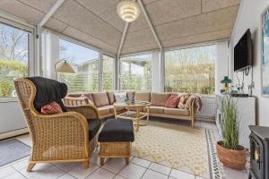 a living room with a couch and chairs and windows at 8592-Glesborg-Muslingevej-9 in Glesborg