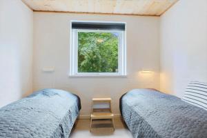 a bedroom with two twin beds and a window at 8837-Glesborg-Enebaervej-30-A in Glesborg