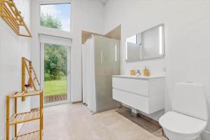 a bathroom with a sink and a toilet and a window at 8846-Glesborg-Skovsoen-76 in Glesborg +27 photos