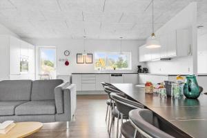 a kitchen and living room with a table and a couch at 8835-Glesborg-Skovsoen-50 in Glesborg