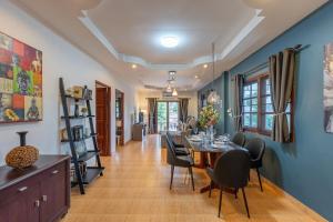a dining room and living room with a table and chairs at Serenity Holiday Villa 2, Karon Beach in Karon Beach