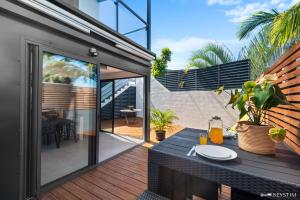 an outdoor patio with a table and a glass door at Ti Kaz Zépices - T2 avec grande terrasse in Le Tampon