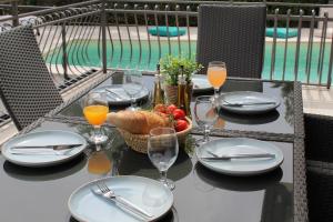 a table with plates of food and glasses of orange juice at Villa Opic, ganze Villa, privater Pool, Meerblick, 4-8 Personen, 3 oder 5 Schlafzimmer in Opric