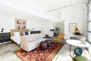 ein Wohnzimmer mit einer weißen Couch und einem Tisch in der Unterkunft Roami at The Mandeville in New Orleans