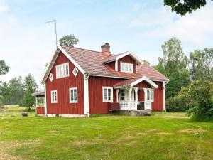 a red house with a green yard at 8 person holiday home in Virestad in Virestad