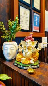 una mesa con una estatua encima de un estante en The Nest, en Ayodhya