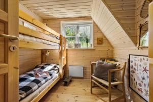 ein kleines Zimmer mit einem Etagenbett und einem Stuhl in der Unterkunft 8538 Grenaa - Klitten 53 in Grenå