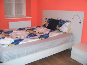 ein Schlafzimmer mit einem Bett mit orangefarbenen Wänden in der Unterkunft Spark Apartment in Budapest
