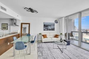 a living room with a glass table and a couch at Icon Brickell Residences by Skyline Rentals in Miami
