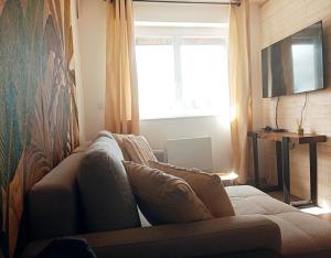 a living room with a couch and a window at centre ville confortable in Gourin